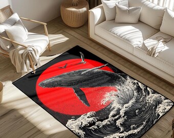 May include: A rectangular area rug featuring a black and white illustration of a whale breaching from the ocean. A large red sun is in the background. The rug is placed on a wooden floor.