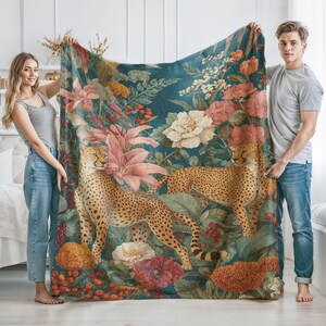 May include: A teal blanket featuring a cheetah design amidst a floral arrangement of pink lilies, white peonies, and other flowers. The cheetahs have a spotted pattern. The blanket is held up by two people.
