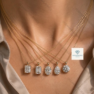 Può includere: Cinque collane in oro con pendenti in pietra preziosa trasparente sfaccettata nei tagli radiant, smeraldo, ovale, a goccia e rotondo. Ogni pendente è incastonato in una montatura d'oro e appeso a una sottile catenina d'oro. Logo OCEANWEAVE JEWELS visibile.