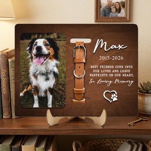 May include: Wooden pet memorial frame with a photo of a dog. The frame includes a leather collar design and the text "Max 2015-2026 Best friends come into our lives and leave pawprints on our heart. In Loving Memory."