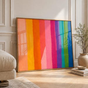 Puede incluir: Una pieza de arte mural rectangular en un marco dorado fino con rayas verticales de colores en tonos melocotón, amarillo, naranja, rojo, rosa, magenta, morado, turquesa, verde y azul, dispuestas en un patrón degradado vibrante.