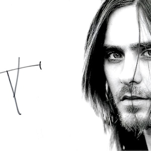 May include: Black and white portrait of a person with long hair and a beard. The person is looking directly at the camera. A simple, abstract line drawing is in the upper left corner.