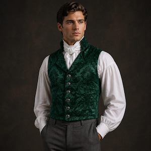 May include: A dark green velvet vest with a floral pattern, buttoned up over a white collared shirt. The vest has a high collar and is paired with gray trousers. The overall style is reminiscent of historical formal wear.