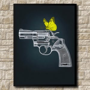 May include: A framed art print featuring a transparent handgun with a yellow butterfly perched on top. The artwork is set against a dark blue background, with a brick wall in the background.