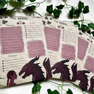 Peut inclure: Plusieurs blocs-notes de planification "Ma Journée" avec une illustration de dragon et de fille. Chaque bloc-notes comprend des sections pour la planification, l'humeur, les listes de tâches et les notes. Les blocs-notes sont beiges et mauves, avec des accents de lierre vert.