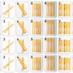 May include: A collection of playing cards featuring various images and numbers. The cards display a green parrot, crossed sticks, and bundles of wooden sticks. Numbers 1 through 9 are represented across the cards.