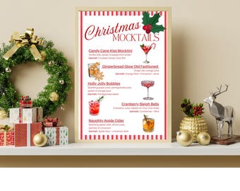 Könnte beinhalten: Ein gerahmter Druck mit der Aufschrift "Christmas Mocktails" in Rot und Weiß, der Abbildungen festlicher Getränke zeigt. Der Druck steht auf einem weißen Regal mit Weihnachtsdekorationen, darunter ein Kranz, Geschenkpakete und goldene Ornamente.