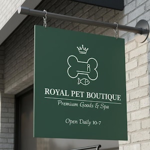 Pode incluir: Uma placa verde escura para "Royal Pet Boutique" pende de uma barra de metal. A placa apresenta um gráfico branco de um osso, uma coroa e um peixe. O texto na placa diz "Premium Goods & Spa" e "Open Daily 10-7". A placa está montada em uma parede de tijolos.
