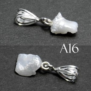 May include: A white pearl pendant with a silver bail. The pearl is irregular in shape and has a rough texture. The pendant is labeled "A16".