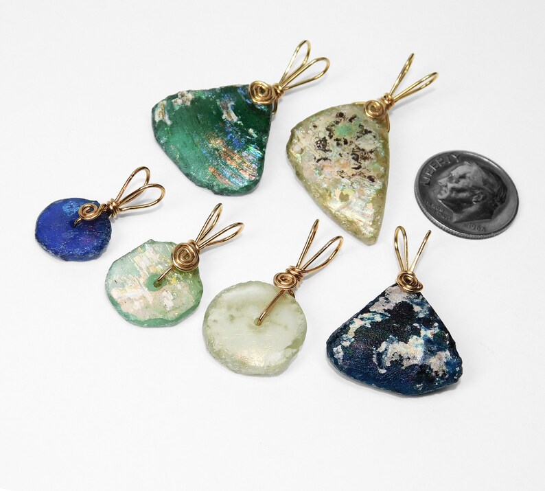 Puede incluir: Seis colgantes de vidrio marino en varias formas y colores, incluyendo azul, verde y transparente. Cada colgante est&aacute; envuelto con alambre dorado y tiene un lazo para un collar. Se incluye una moneda como referencia de tama&ntilde;o.