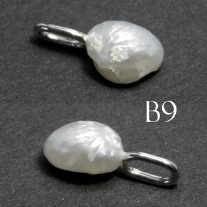 May include: Two white baroque pearl pendants with silver-tone loops. The pearls have irregular shapes and a lustrous surface. The pendants are displayed against a dark gray background. The text "B9" is visible.