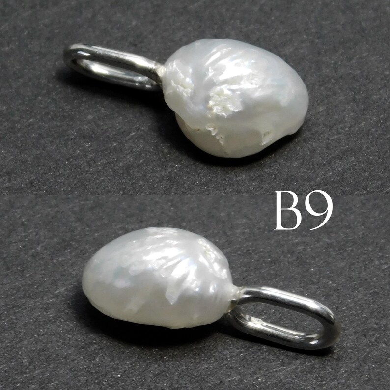 May include: Two white baroque pearl pendants with silver-tone loops. The pearls have irregular shapes and a lustrous surface. The pendants are displayed against a dark gray background. The text "B9" is visible.