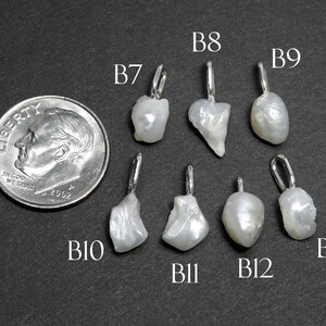 May include: A collection of seven irregularly shaped, white pearl pendants with silver-colored bails, displayed next to a U.S. dime for size comparison. The pendants are labeled B7, B8, B9, B10, B11, B12, and B13.