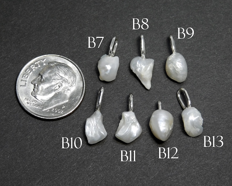 May include: A collection of seven irregularly shaped, white pearl pendants with silver-colored bails, displayed next to a U.S. dime for size comparison. The pendants are labeled B7, B8, B9, B10, B11, B12, and B13.