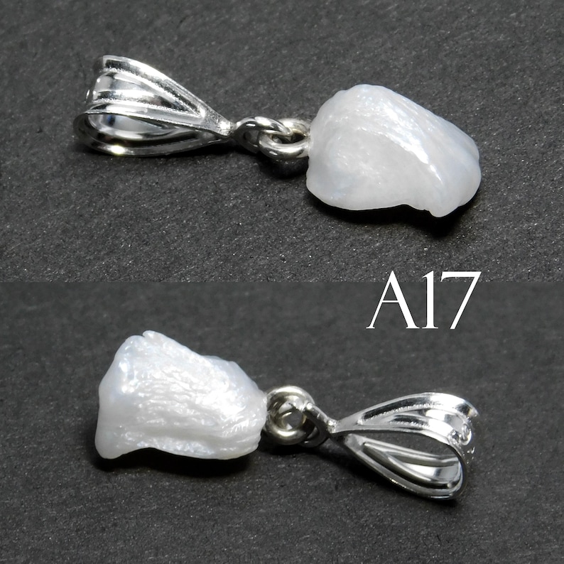 May include: A white pearl pendant with a silver bail. The pearl is irregular in shape and has a smooth, shiny surface. The bail is a simple loop with a slightly textured finish. The pendant is labeled "A17".