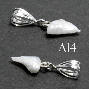 May include: A white pearl pendant with a silver bail. The pearl is irregular in shape and has a rough texture. The pendant is labeled "A14".