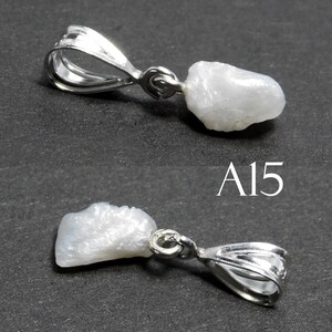 May include: A white, rough, natural gemstone pendant with a silver bail. The pendant is shown from two angles. The text "A15" is visible in the image.