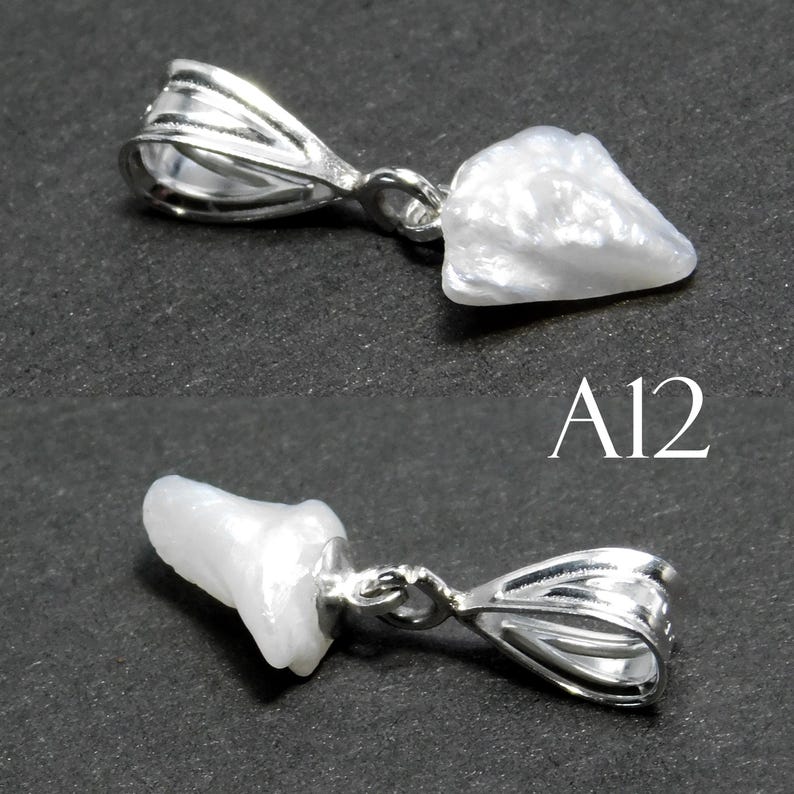 May include: A white pearl pendant with a silver bail. The pearl is irregular in shape and has a smooth, shiny surface. The bail is a simple, open loop design. The pendant is labeled "A12".