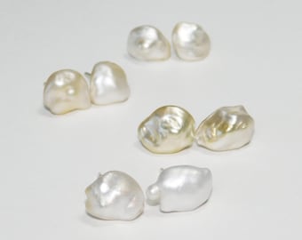 May include: A set of six pearl earrings in various shades of white and cream. The earrings are all irregular in shape and have a natural, organic look.