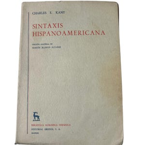 May include: A vintage book titled "Sintaxis Hispanoamericana" by Charles E. Kany. The cover is a light beige with red and black text. The book is part of the "Biblioteca Románica Hispánica" series, published by Editorial Gredos in Madrid.