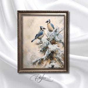 Puede incluir: Obra de arte enmarcada con dos arrendajos azules posados en una rama de pino nevada. Las aves tienen marcas azules, blancas y negras. La obra está en un marco plateado y tiene un fondo suave y neutro.