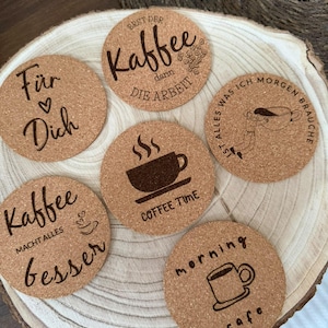 Könnte beinhalten: Sechs runde Untersetzer aus Kork mit verschiedenen kaffeebezogenen Motiven und Texten. Die Texte lauten "Für Dich", "ERST DER Kaffee dann DIE ARBEIT", "IST ALLES WAS ICH MORGEN BRAUCHE", "Kaffee MACHT ALLES besser", "COFFEE TIME" und "morning cafe".