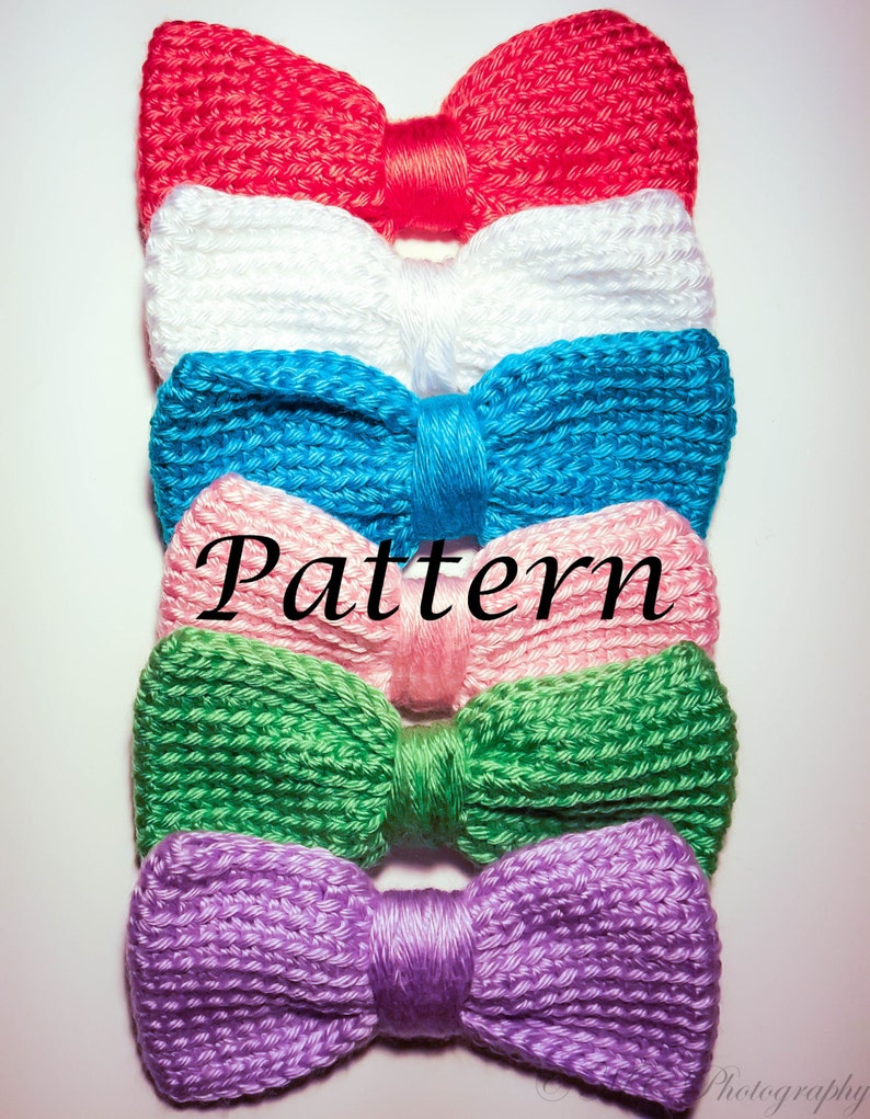 May include: A stack of five knitted bow ties in different colors: red, white, blue, pink, green, and purple. The bow ties are arranged in a vertical stack, with the red bow tie on top and the purple bow tie on the bottom. The word "Pattern" is written in white letters on a pink bow tie.