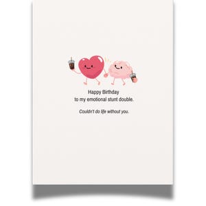 May include: A white greeting card featuring a cartoon illustration of a pink heart and a pink brain holding hands while each holds a small iced coffee. The text reads: Happy Birthday to my emotional stunt double. Couldn't do life without you.