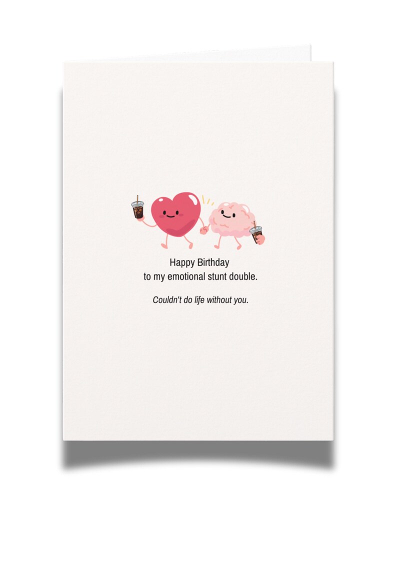 May include: A white greeting card featuring a cartoon illustration of a pink heart and a pink brain holding hands while each holds a small iced coffee. The text reads: Happy Birthday to my emotional stunt double. Couldn't do life without you.