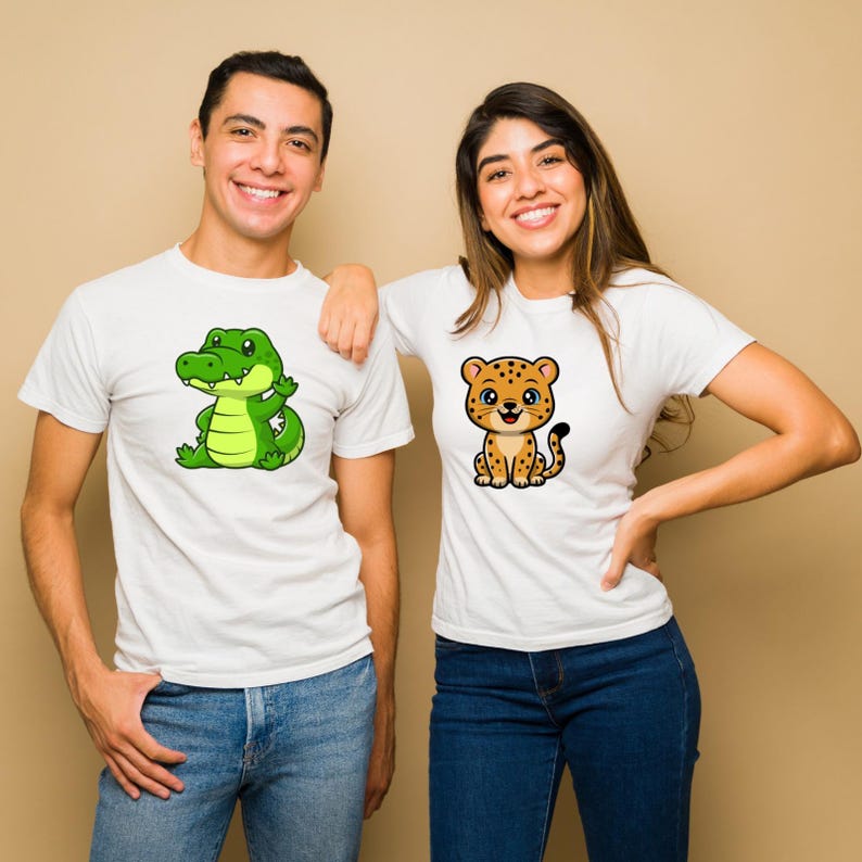 May include: Two people wearing white t-shirts with cartoon animal graphics. One shirt features a green alligator, the other a cheetah. Both shirts are paired with blue jeans. The background is a solid tan color.