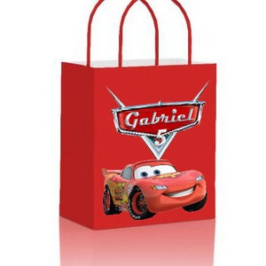 May include: Red and white gift bag with a red race car and the name Gabriel on a silver shield. The car has a number 5 on the side.