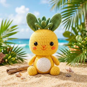 Pode incluir: Um peluche de croché amarelo em forma de ananás com orelhas de folhas verdes, olhos de plástico preto, bochechas bordadas a laranja e uma mancha circular branca na barriga. A figura sentada tem braços e pernas pequenos sobre a areia.