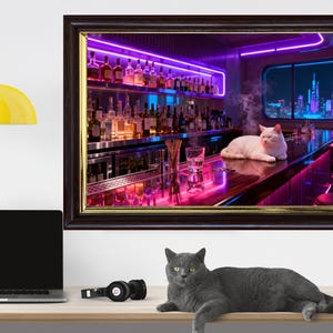 May include: A framed print depicts a white cat lounging on a bar in a neon-lit setting. The bar is stocked with bottles, and a city skyline is visible through a window. A gray cat rests on a wooden surface below the print.