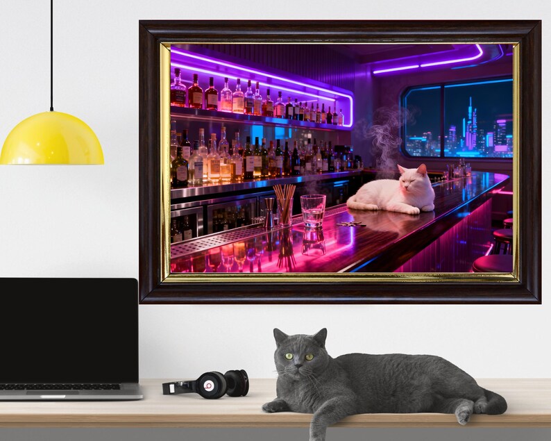 May include: A framed print depicts a white cat lounging on a bar in a neon-lit setting. The bar is stocked with bottles, and a city skyline is visible through a window. A gray cat rests on a wooden surface below the print.