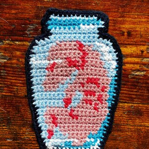 Tapisserie au crochet de cochon foetal dans un bocal (découpée et rectangulaire)