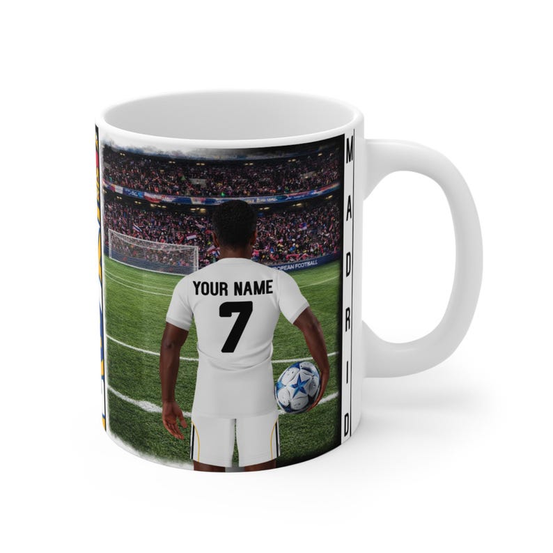 Peut inclure: Mug en c&eacute;ramique blanche avec un joueur de football en uniforme blanc, portant le num&eacute;ro 7 et le texte "YOUR NAME". Le fond repr&eacute;sente un terrain de football et un stade, avec le mot "MADRID" imprim&eacute; sur le c&ocirc;t&eacute;.