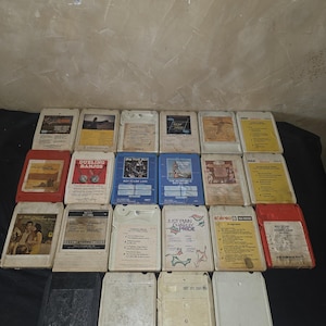 May include: A collection of vintage 8-track tapes, featuring various album covers with text and graphics. The tapes are in different colors, including red, blue, and yellow. Some tapes have the RCA logo.