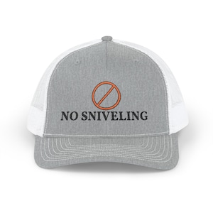 May include: A heather grey trucker hat with white mesh back panels and a curved brim. The front features an embroidered orange circle with a diagonal line through it, positioned above the black embroidered text NO SNIVELING.