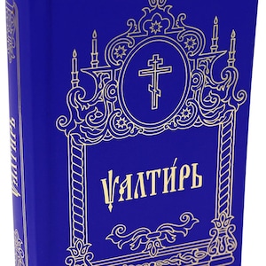 May include: A blue book with gold ornate detailing and the word "Vалтирь" in gold lettering. The cover features a cross within an oval and decorative elements. A blue ribbon bookmark is visible.