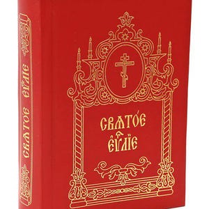 May include: A red book with gold lettering and a cross design. The book's cover features ornate gold embellishments and the text "Святое Евангелие". A red ribbon bookmark is visible at the top. The spine also has gold text.