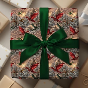 May include: A square gift box wrapped in paper featuring a repeating pattern of red and green dragons flying over mountain landscapes and stone castles. The box is tied with a wide, dark green satin ribbon tied in a large bow at the center.