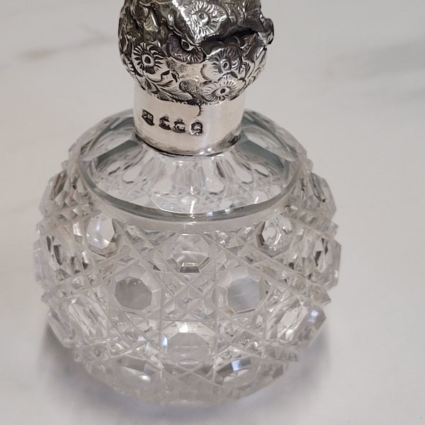 Ancienne bouteille de parfum en verre ronde avec couvercle floral argenté, Londres