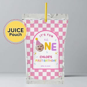 Può includere: Una busta di succo trasparente con un motivo a scacchi rosa e bianco. La busta presenta il testo "IT'S FUN to be ONE" e "CHLOE'S FIRST BIRTHDAY" con la foto di un bambino. Una cannuccia gialla è inserita nella parte superiore.