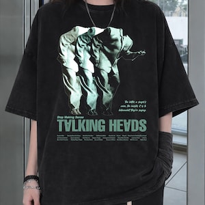 May include: Black oversized t-shirt featuring a graphic of three figures in suits with the text "TALKING HEADS" in green. The shirt also includes the text "Stop Making Sense" and other text below the band's name.