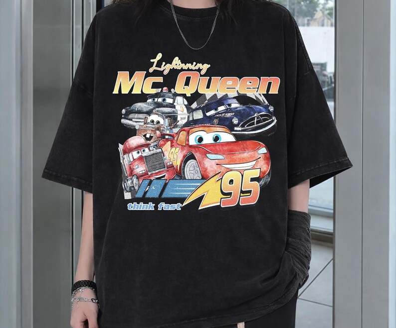 Puede incluir: Camiseta negra con un dise&ntilde;o de Rayo McQueen de la pel&iacute;cula Cars, con el texto "Lightning McQueen" y "95". El dise&ntilde;o incluye otros personajes de Cars y la frase "think fast".