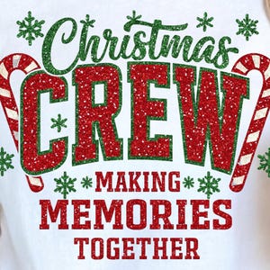 May include: White t-shirt with a festive Christmas design. The shirt features the words "Christmas CREW" in red glitter, with green accents and candy cane graphics. The phrase "MAKING MEMORIES TOGETHER" is below.