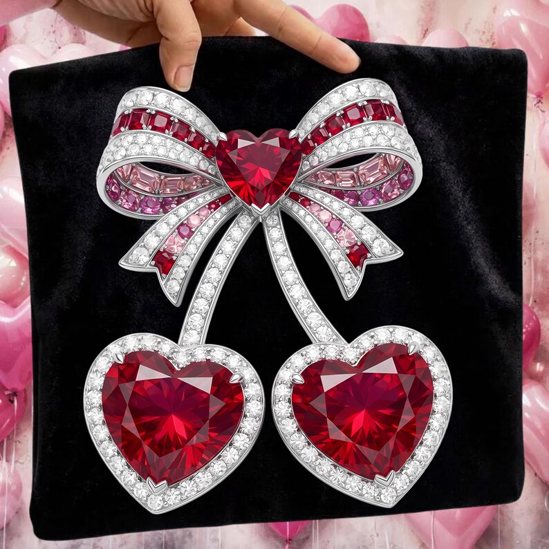 Puede incluir: Broche con forma de lazo y dos corazones. El broche presenta un gran rub&iacute; en forma de coraz&oacute;n en el centro del lazo y dos colgantes de coraz&oacute;n de rub&iacute;. El broche est&aacute; incrustado con piedras preciosas blancas y rosas y engastado en metal plateado.