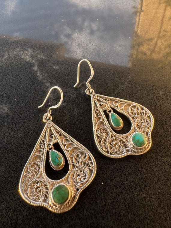 Handmade sterling silver filigree drop earrings set with natural turquoise stones.