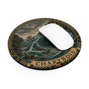 May include: A round mouse pad featuring a detailed illustration of a ship in a turbulent sea with a whirlpool, framed by a gold Greek key border. The text CHARYBDIS is printed in gold at the bottom. A white computer mouse rests on the surface.
