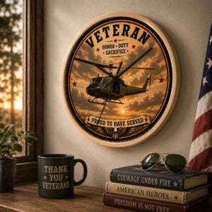 May include: A round wall clock featuring a military helicopter against a sunset sky, with the text VETERAN, HONOR, DUTY, SACRIFICE, and PROUD TO HAVE SERVED. The clock has a light wood frame and black hands, displayed alongside a mug and books.